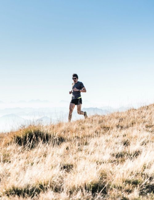 Man running on mountain with bluetooth earphones